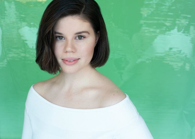 A young woman in a white blouse over a bright green background.